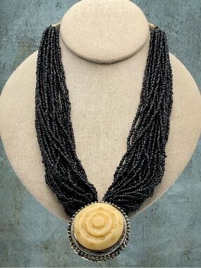Vintage Multi Strand Black Seed Bead Necklace with Carved Bone Medallion